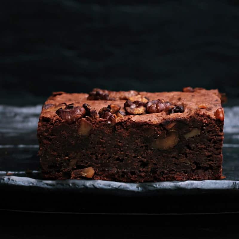 A dark chocolate and walnut brownie on slate