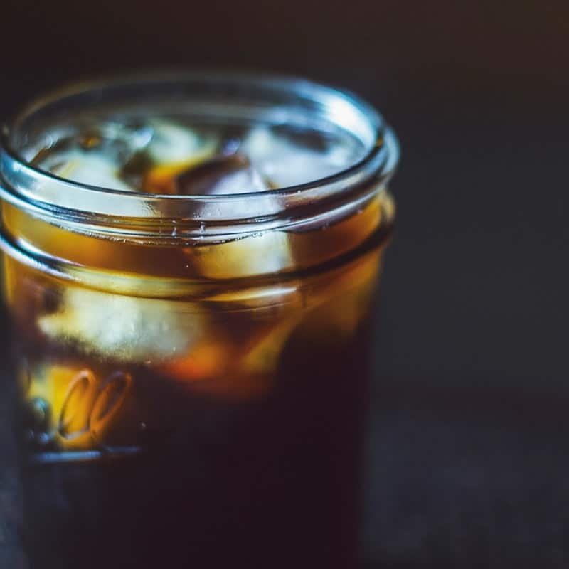 Cold brew coffee poured over ice in a glass jar