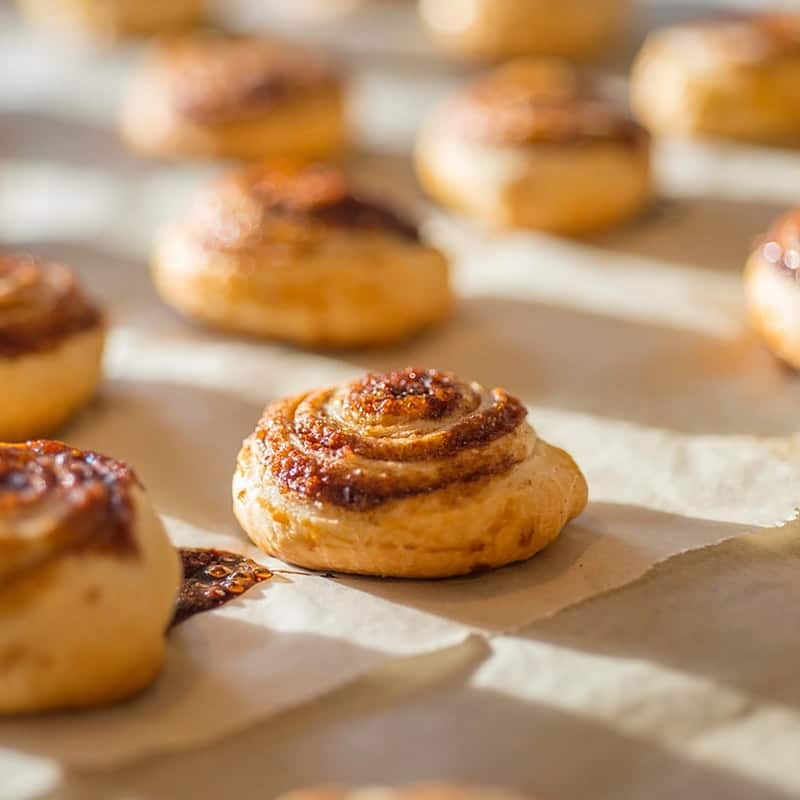 Cinnamon morning buns cooling in rows on baking paper