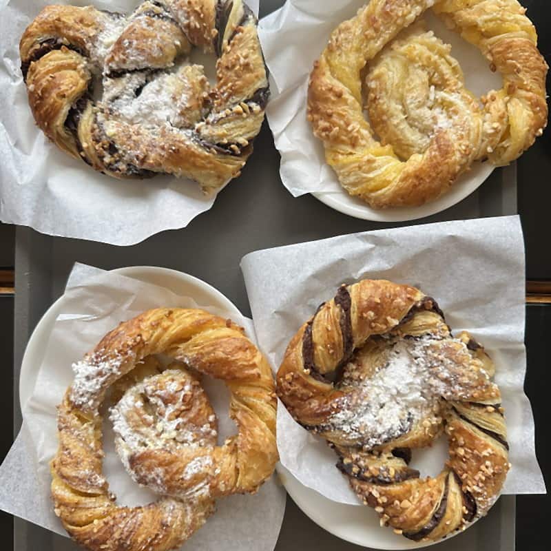 Chocolate-filled pastries dusted with icing sugar, resting on baking paper