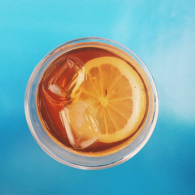 Iced tea with a citrus wheel, seen from above on a blue surface