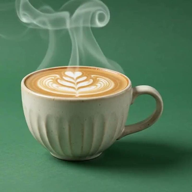Cappuccino with a rosetta latte-art pattern in a fluted ceramic cup