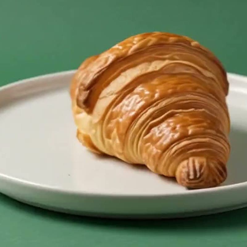 Caramelised kouign-amann pastry on a ceramic plate