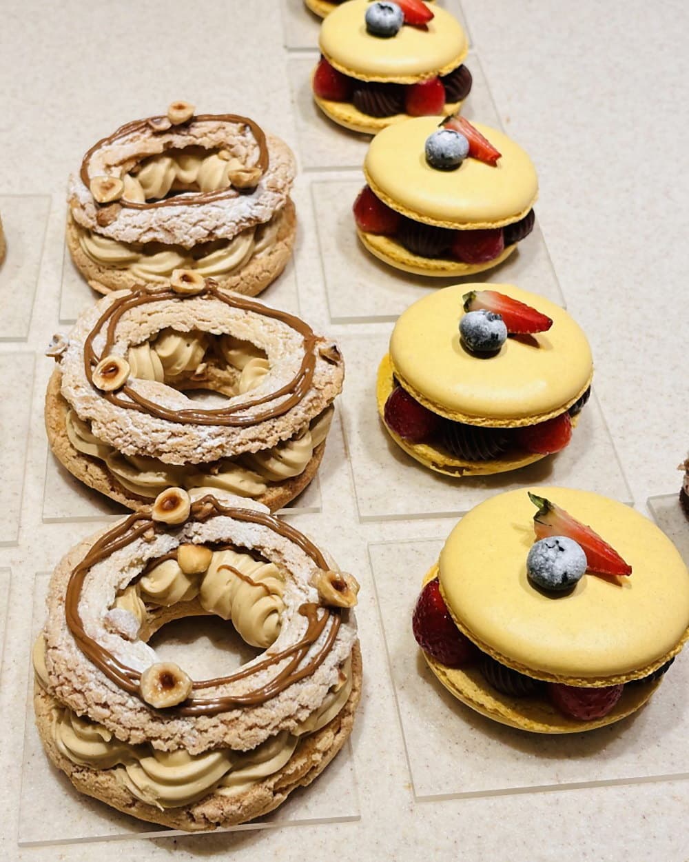 An assortment of choux pastries and fruit tarts arranged on a tray
